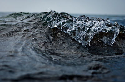 Close-up of rocks in sea against sky