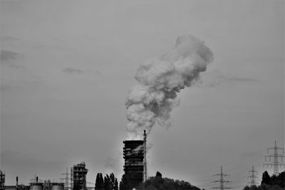 Smoke emitting from chimney against sky