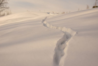 Snow covered land against sky