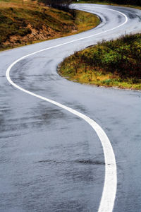 Winding road amidst grassy field