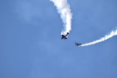 Low angle view of airshow against sky