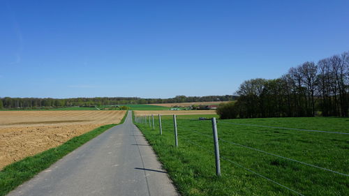 Scenic view of field against clear blue sky