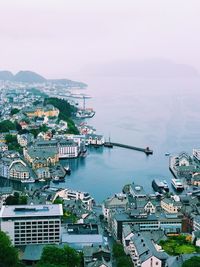 High angle view of city by sea against sky