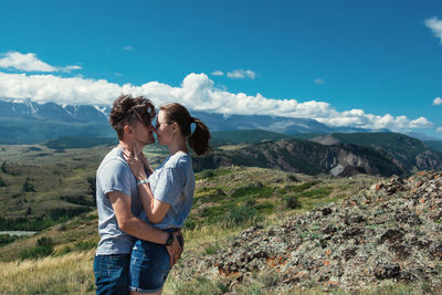 Rear view of man standing on mountain against sky