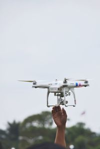 Person holding airplane against sky