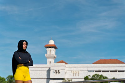 Woman in hijab standing against sky