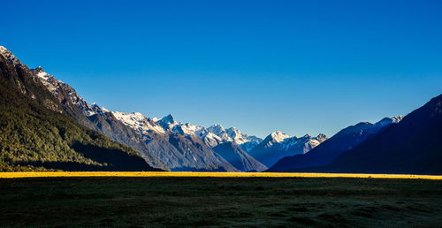 Scenic view of mountains against blue sky