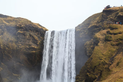 Scenic view of waterfall against sky