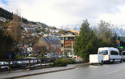 Cars on road against sky in city