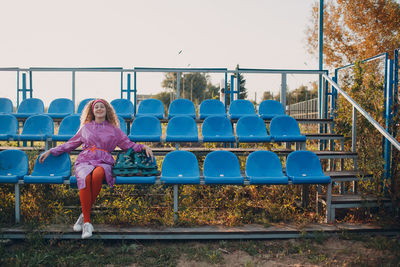 Full length of woman sitting against clear sky