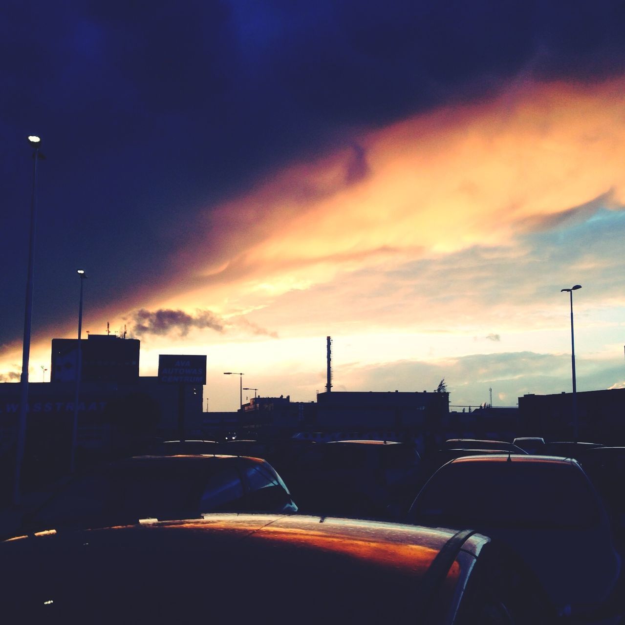 sunset, sky, silhouette, building exterior, transportation, built structure, cloud - sky, architecture, mode of transport, dusk, city, cloud, cloudy, outdoors, orange color, crane - construction machinery, low angle view, nautical vessel, building, street light