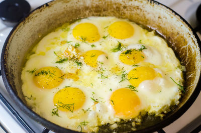 Fried eggs in the home kitchen, omelette with herbs and spices in a frying pan