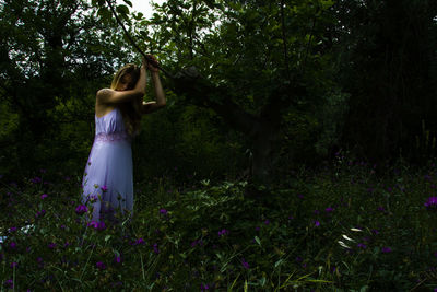 Woman standing by tree on field