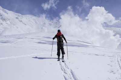 Man standing on snow covered landscape against sky