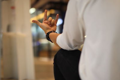 Midsection of man gesturing at home