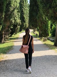 Full length of woman on road against trees