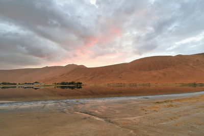 1118 sumu jaran lake and badain jaran desert temple-sand megadunes reflected on mirror water. china.