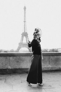 Rear view of woman standing on tower in city