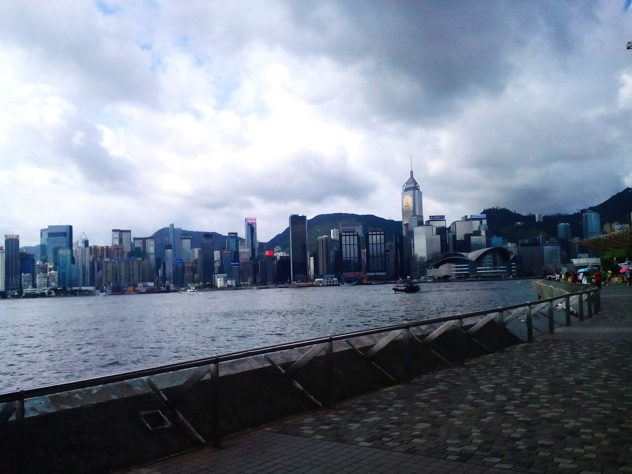 architecture, sky, built structure, building exterior, cloud - sky, cloudy, water, cloud, transportation, city, river, weather, railing, incidental people, bridge - man made structure, day, overcast, outdoors, mode of transport, travel destinations