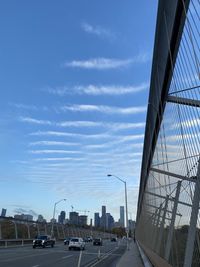 Cars on bridge against sky in city