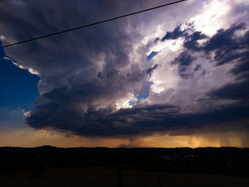 Low angle view of dramatic sky over silhouette landscape