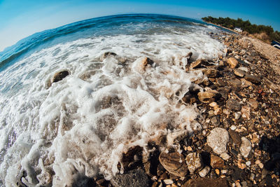 Scenic view of rocks on beach against sky