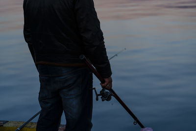 Rear view of man fishing in lake