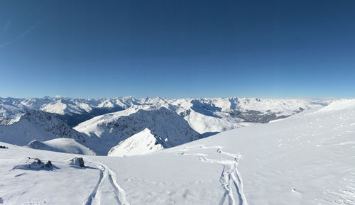 Scenic view of snowcapped mountains against clear blue sky