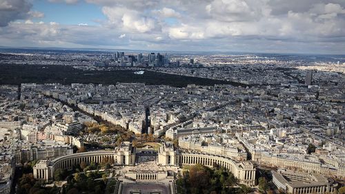 High angle view of city buildings against cloudy sky