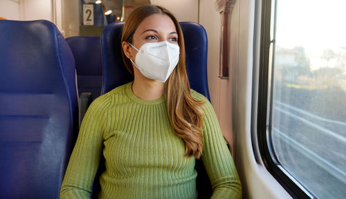 Portrait of woman traveling on public transport wearing protective medical mask. 