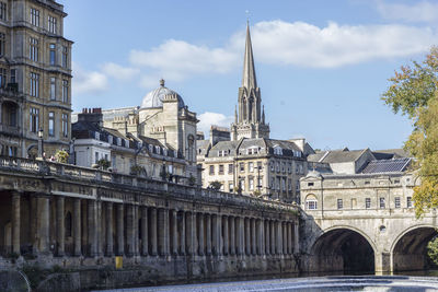 Pulteney bridge by buildings against sky in city