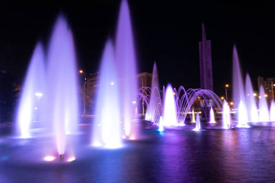 Illuminated fountain at night