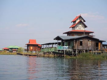 Houses by lake against sky