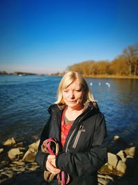 Beautiful woman standing at lake against sky