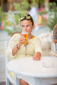 Young woman drinking glass on table