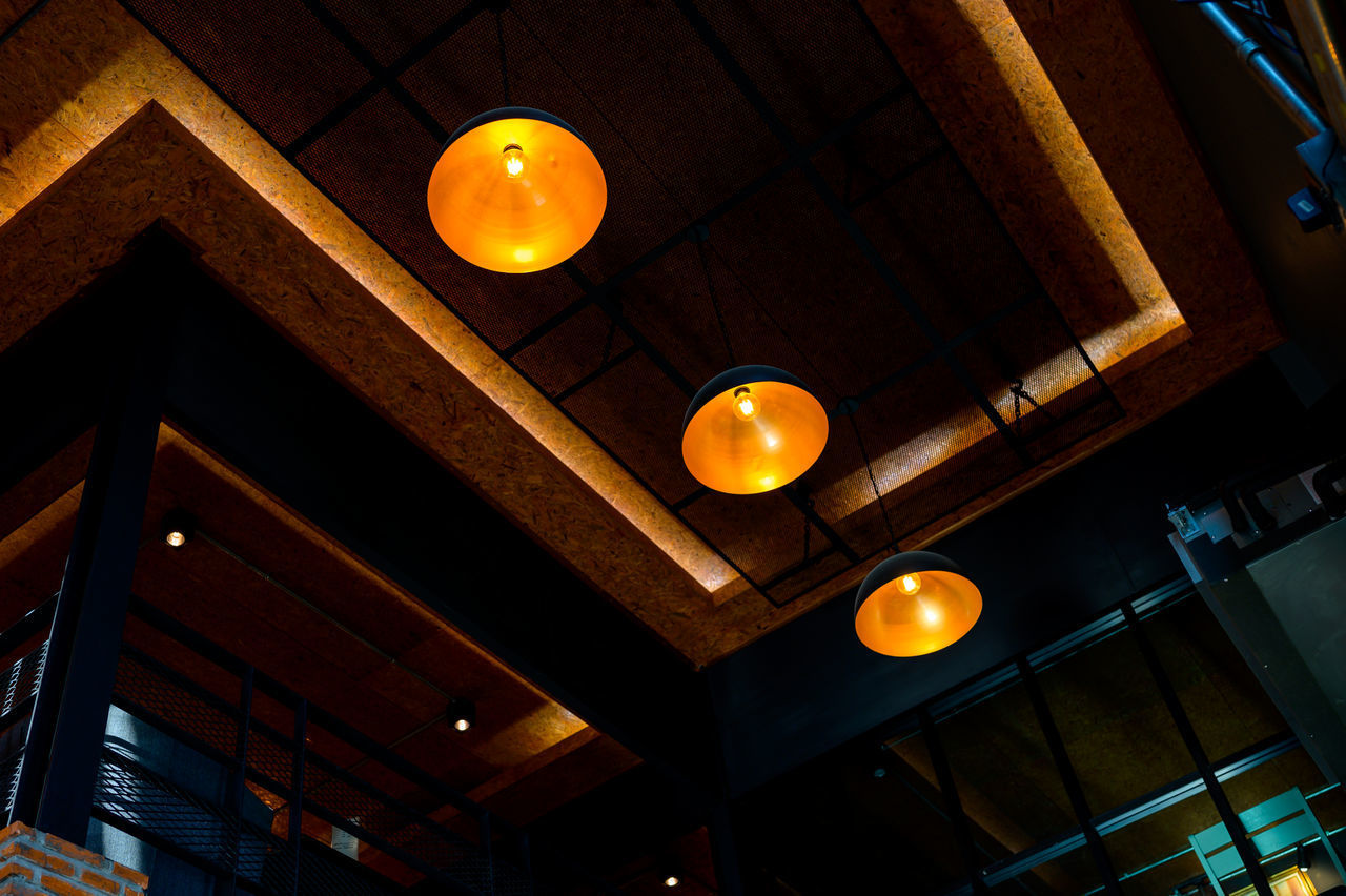 LOW ANGLE VIEW OF ILLUMINATED PENDANT LIGHT HANGING IN BUILDING