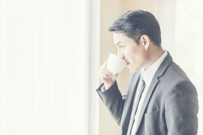 Side view of a man holding coffee cup