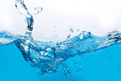 Close-up of water splashing against blue background
