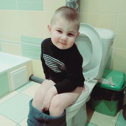 Boy sitting in bathroom