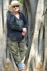 Portrait of man standing against tree trunk