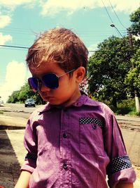 Boy with sunglasses against sky
