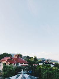 Houses and buildings in city against clear sky