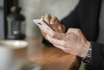 Midsection of man using mobile phone