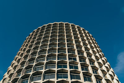 Low angle view of modern building against blue sky