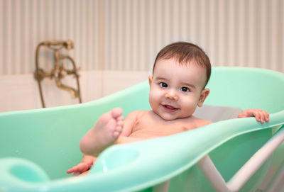 Close-up portrait of smiling baby in bath