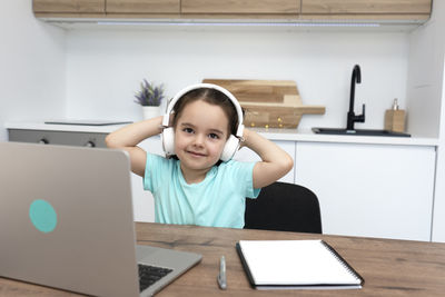 Portrait of boy using laptop at home