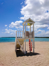 Lifeguard hut on beach against sky