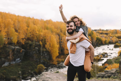 Happy people in love are travel hike in nature in the autumn forest. romantic trip to countryside