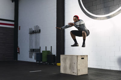 Athlete practicing box squats in gym