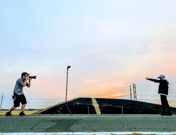 Full length of man photographing against sky